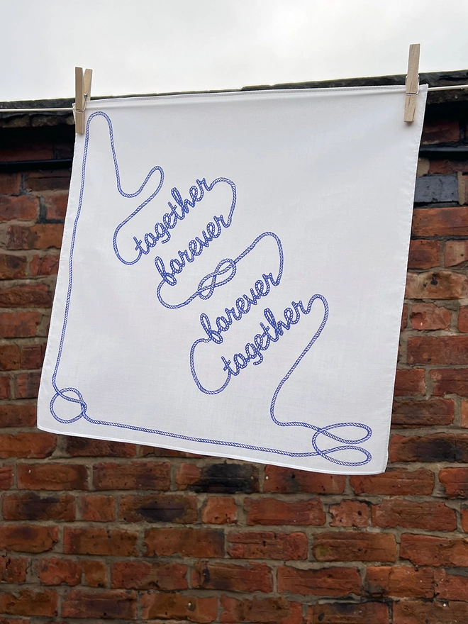 A Mr.PS Together Forever Handkerchief hanging outside on a washing line