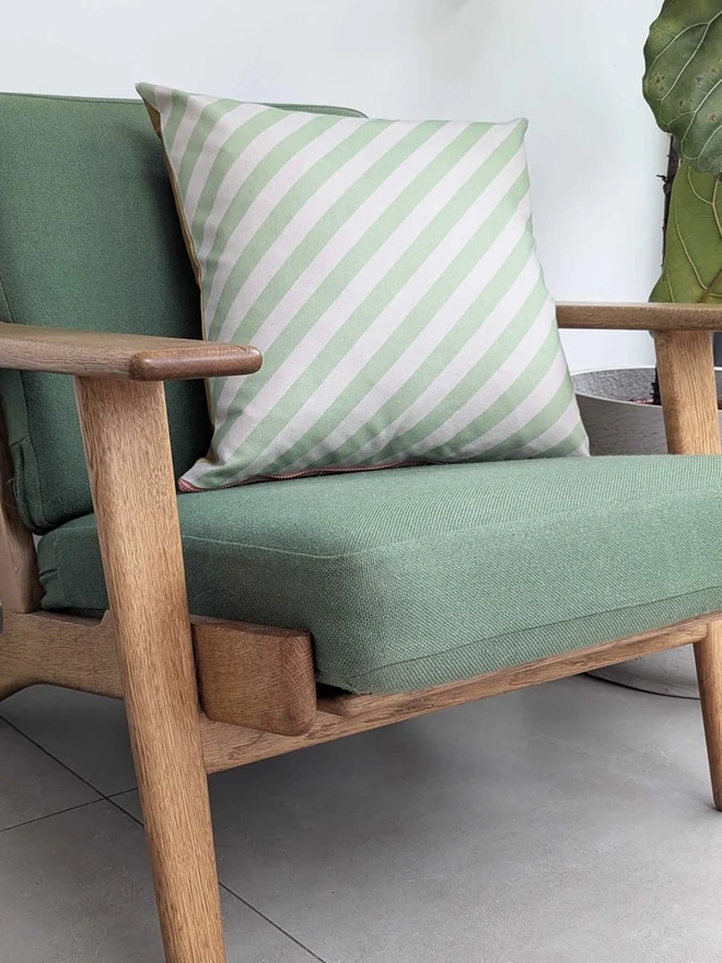Cotton Print Patterned Cushion, a cushion sitting on a green chair in a kitchen. 