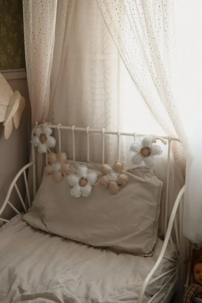 Daisy Flower Garland Decoration, a hanging colourful daisy flower garland sitting in a child's bedroom. 