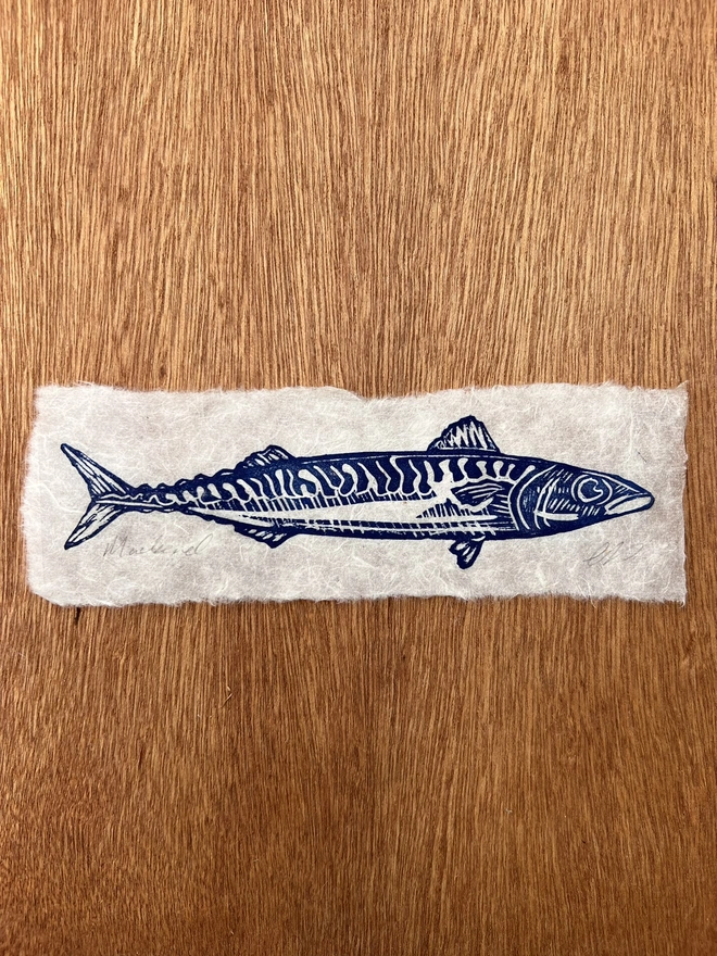 Hand-printed mackerel lino print on natural handmade paper, featuring a bold graphic illustration of a mackerel.