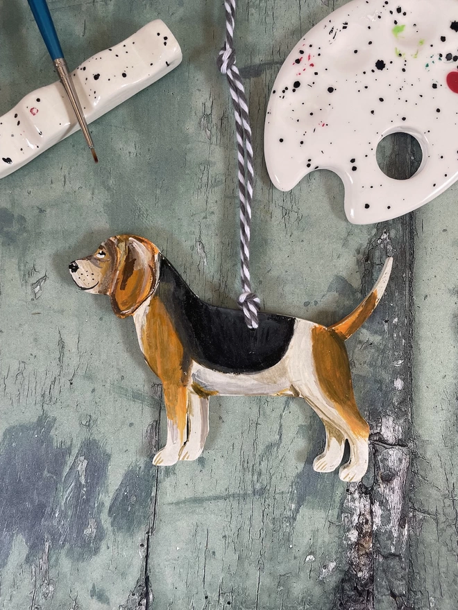 Beagle dog portrait decoration placed next to a paintbrush and paint palette 