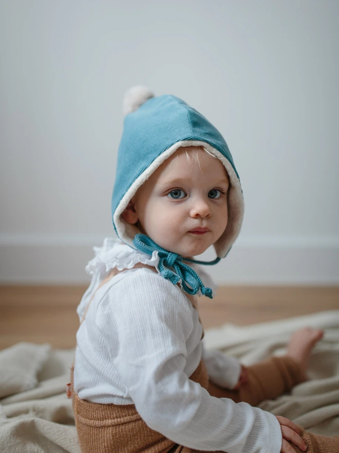 baby in blue pixie hat looking very sweetly at the camera