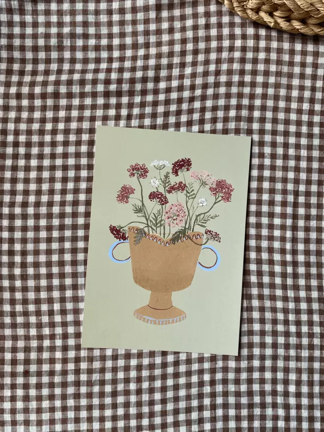 Print of Queen Anns Lace flowers in a vase on gingham tablecloth.