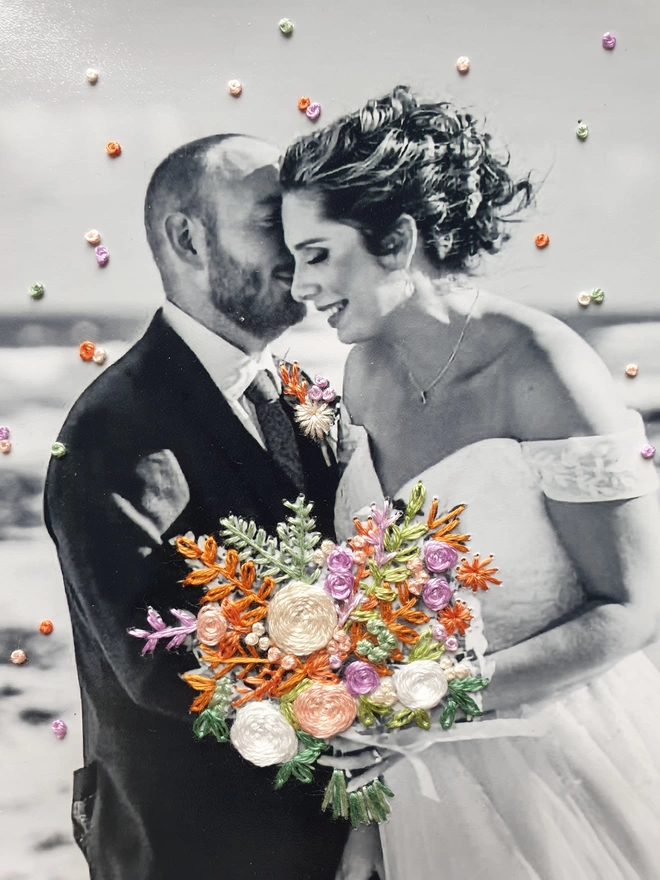 Close up image of wedding photo in B&W with hand embroidered bouquet & confetti