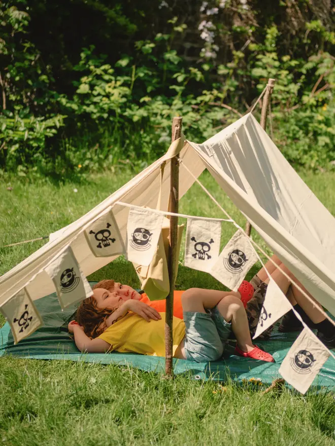 Children in a pirate den held up by wooden den poles