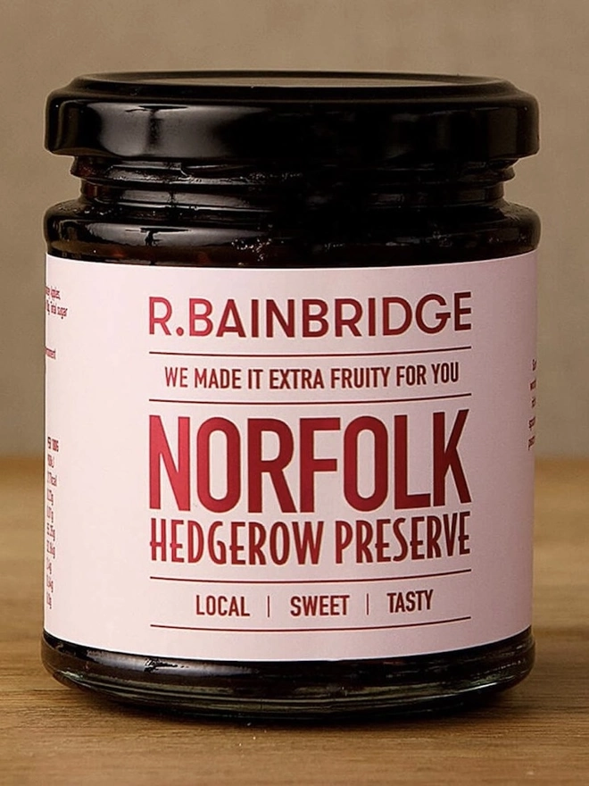 Norfolk Hedgerow (Set Of 1, 2 Or 3), a jar of chutney sitting on a wooden surface against a plain backdrop. 