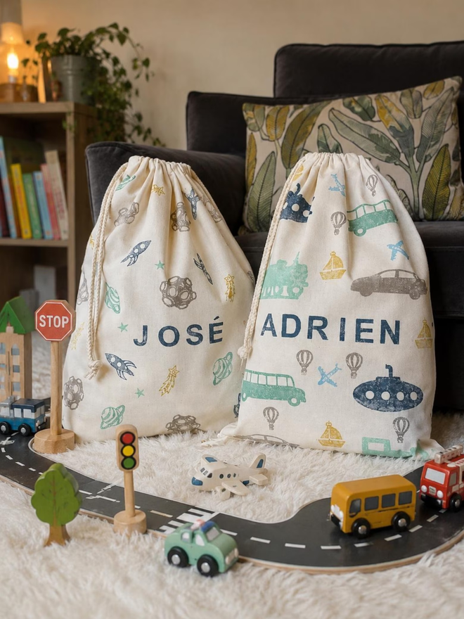 personalised toy sack. two drawstring bags with printed dinosaurs and rockets and personalised names.