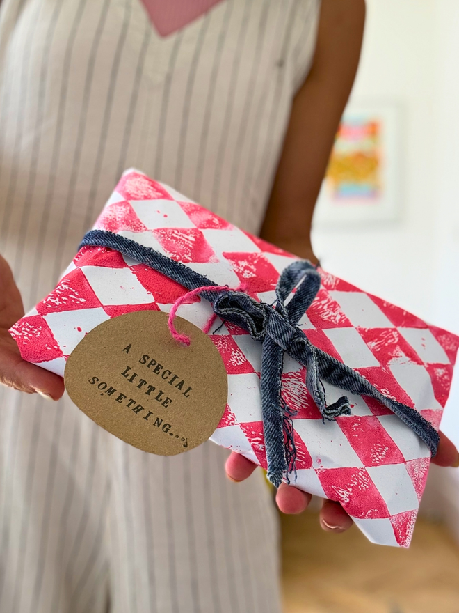 Gift wrapping - pink harlequin hand printed paper with a denim ribbon and gift tag