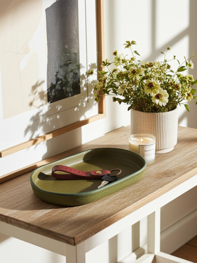 olive leather tray on a hallway table with vase of flowers 