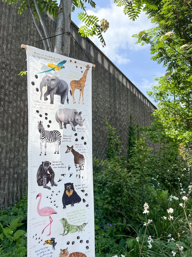 Fabric Height Chart with Illustrations of animals, hung on a tree