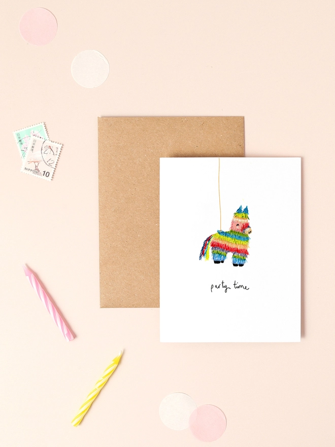 A vibrant illustration of a rainbow-colored piñata adorned with festive confetti, accompanied by the playful message "Party Time" in a whimsical, handwritten font. The design features bold, cheerful colors and a minimalist layout, capturing the joy and excitement of a celebration.