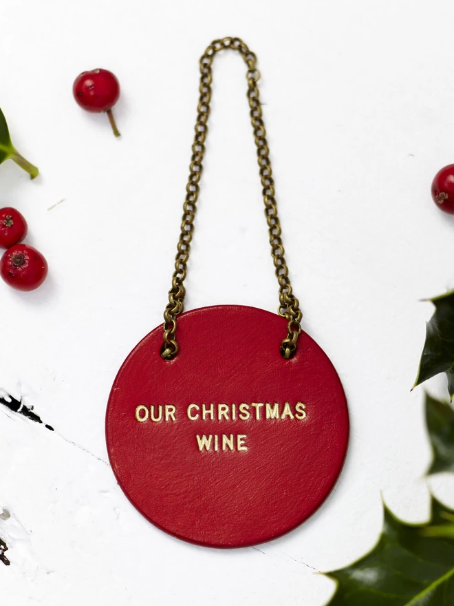 'Our Christmas Wine' written in gold on aRed leather tag