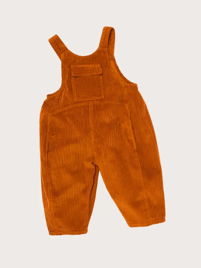Front flat lay of Studio Koter Kai dungarees in brown corduroy, with button straps and a side patch pocket