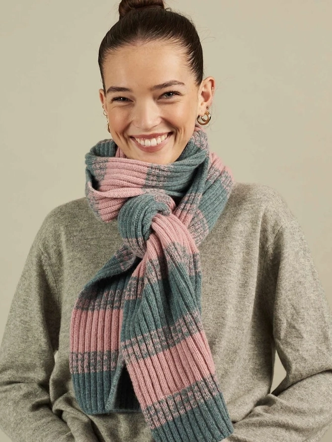 Lambswool Striped Scarf, a woman wearing a colourful striped scarf indoors. 