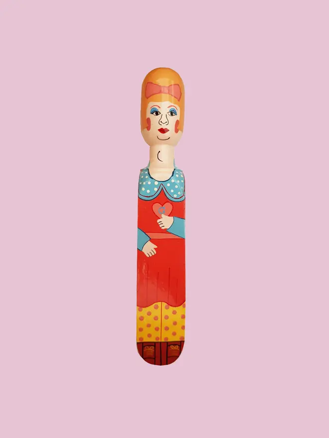 Wooden Door Stopper (Pez), a colourful wooden door stop sitting on a white surface. 