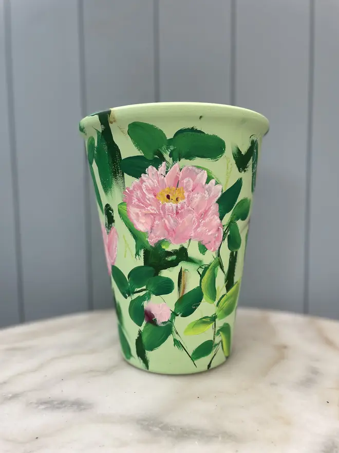 Unique hand-painted terracotta pot featuring pink peonies on a pale green background
