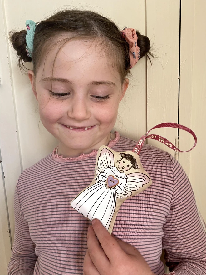 little girl looking at a tooth fairy doll