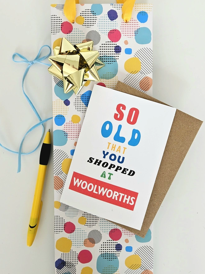 A photograph of the front of a humorous A6 greeting card illustrated using brightly coloured text and the retro shop logo. The text says so old you shopped at Woolworths