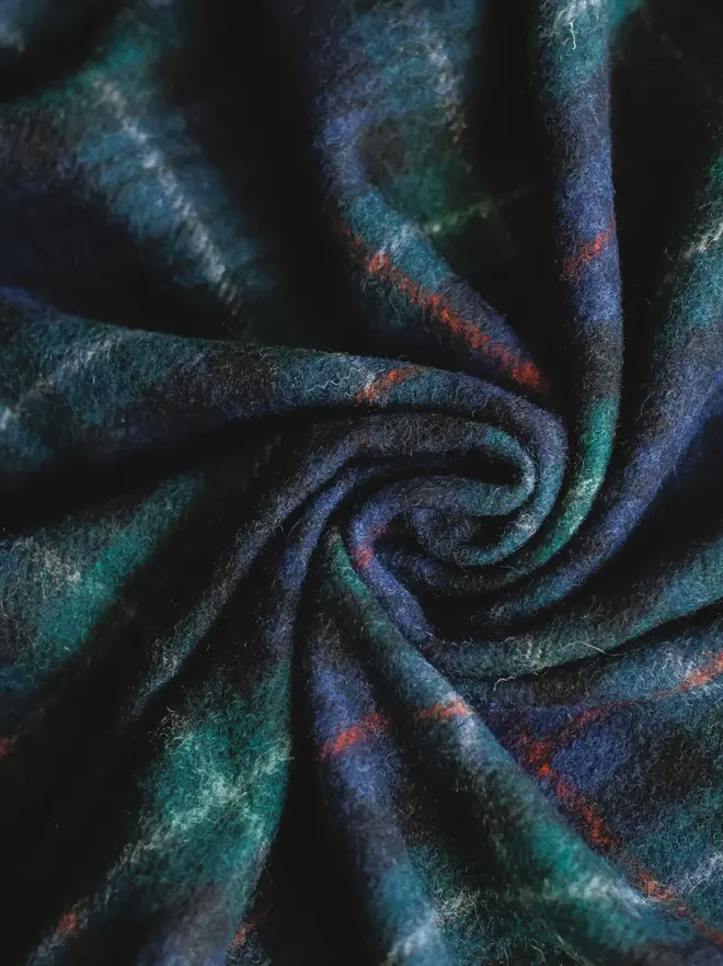 Mackenzie Wool Blanket, a wool blanket curled up. 