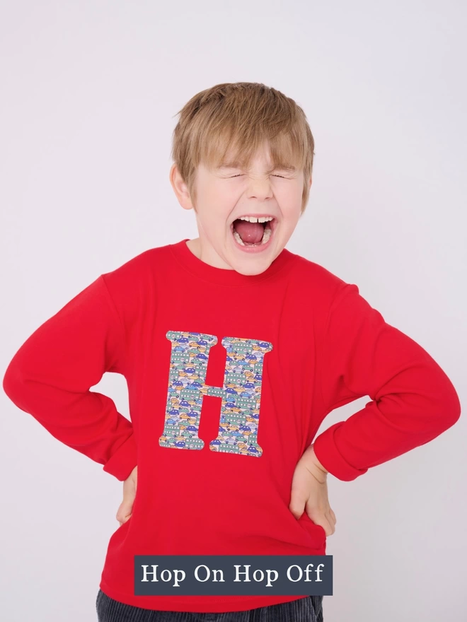 a 5 year old boy wearing a red long sleeve cotton t-shirt appliquéd with a letter H in Liberty print featuring vintage cars 