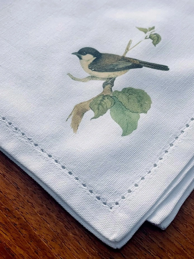 a white cotton napkin printed with a sparrow