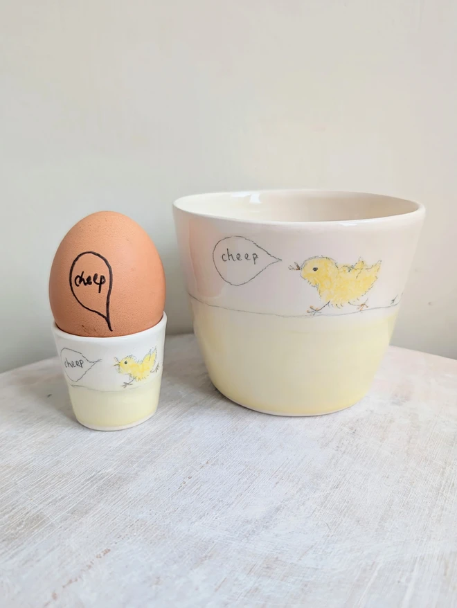 Yellow Easter egg cup and b ajer tumbler handleless cup with yellow chick bird and the word cheep