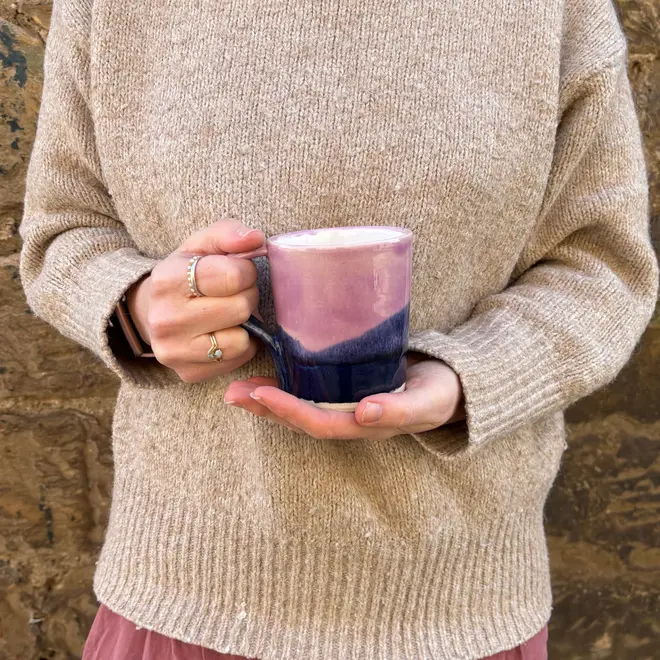 Landscape Standard Mug, a person wearing a jumper holding a colourful mug in front of them. 