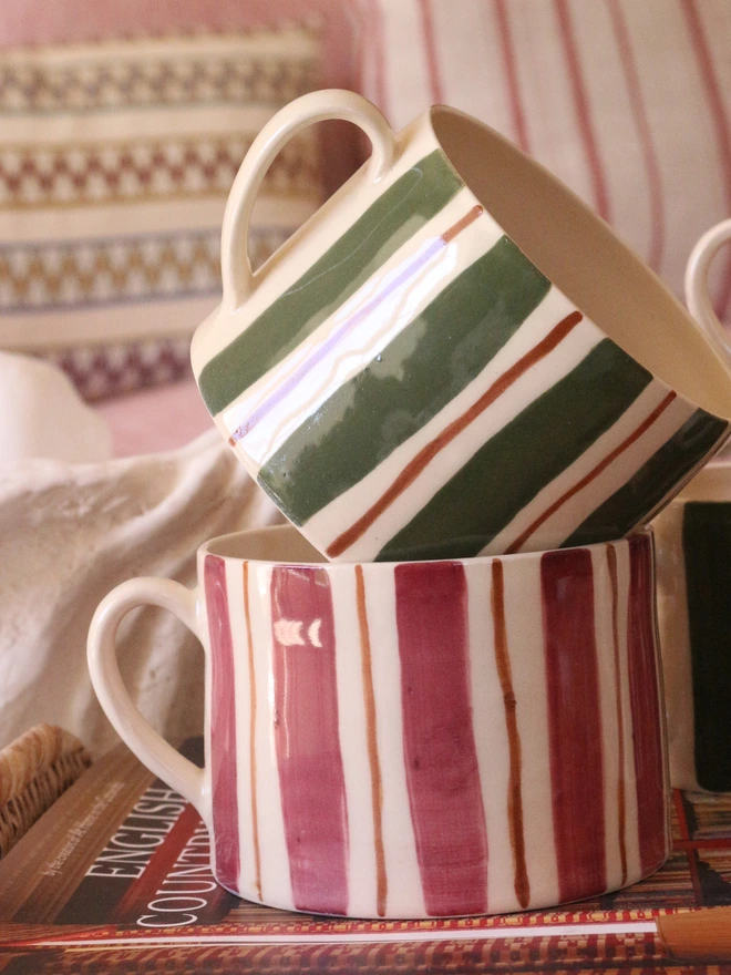 burgundy, green and brown stripe ceramic cup stacked on top of each other hand painted stripes