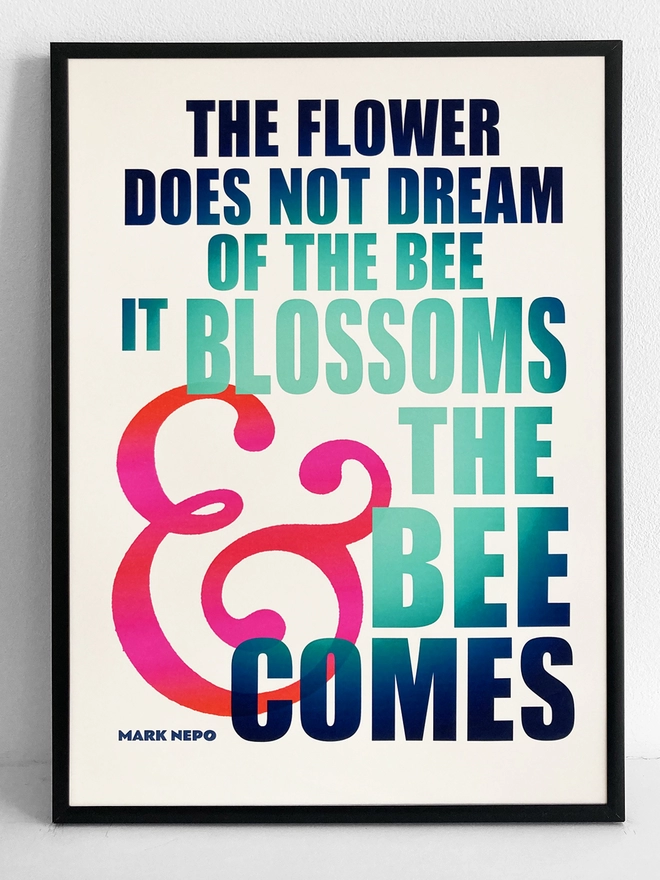 Framed multicoloured typographic print of “The flower does not dream of the bee, it blossoms and the bee comes” by Mark Nepo.