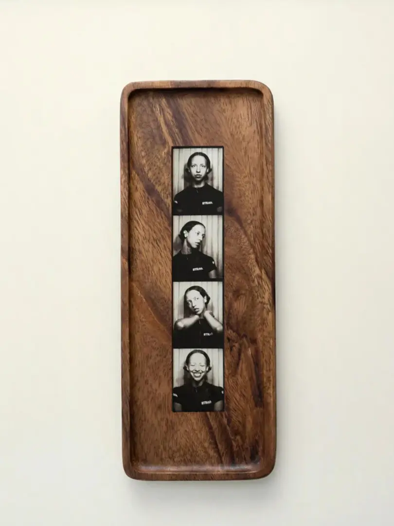 Walnut Photobooth Frame For Photo Strip Prints, hanging on a white wall. 