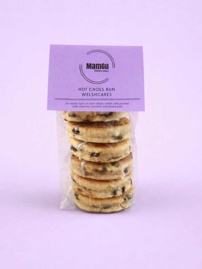 6 Hot Cross Bun Welsh Cakes with a light purple MamGu Welshcakes label on top and a light purple studio background