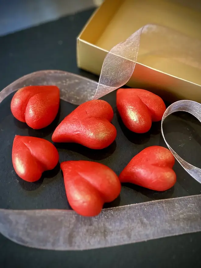 Marzihearts Valentines Chocolates (Box Of 6, 9, 12), cherry valentines heart chocolates grouped together on a black surface. 