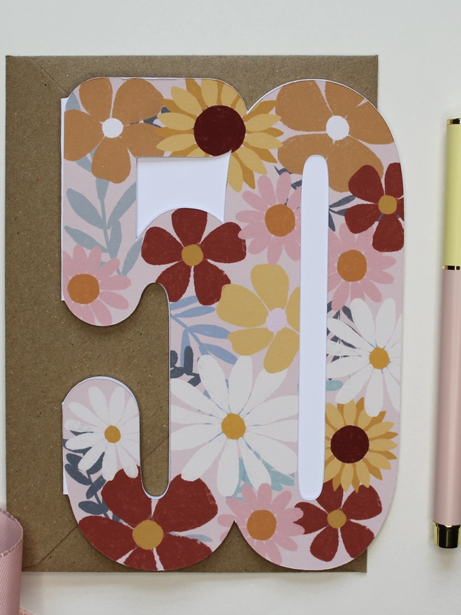 floral 50th birthday card. card shaped like 50 decorated with colourful flowers.