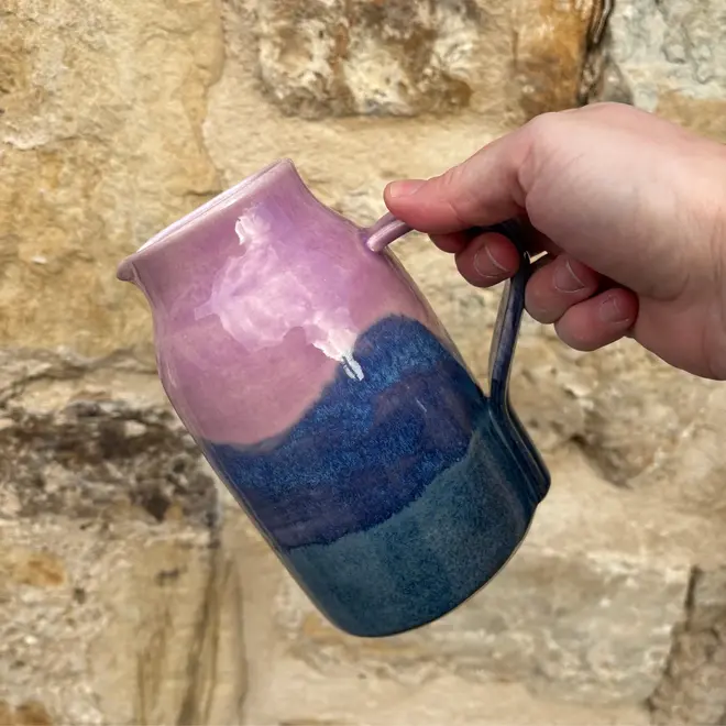 Landscape Medium Jug, a colourful jug sitting held against a brick backdrop. 