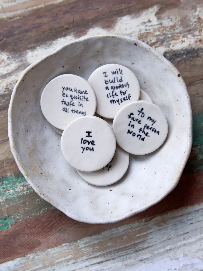 Small ceramic love token. A group of ceramic love tokens in a ceramic bowl