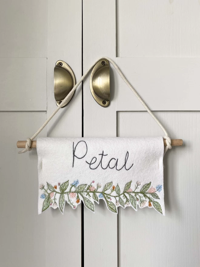 Flower Trim Personalised  Felt Banner hanging on wardrobe