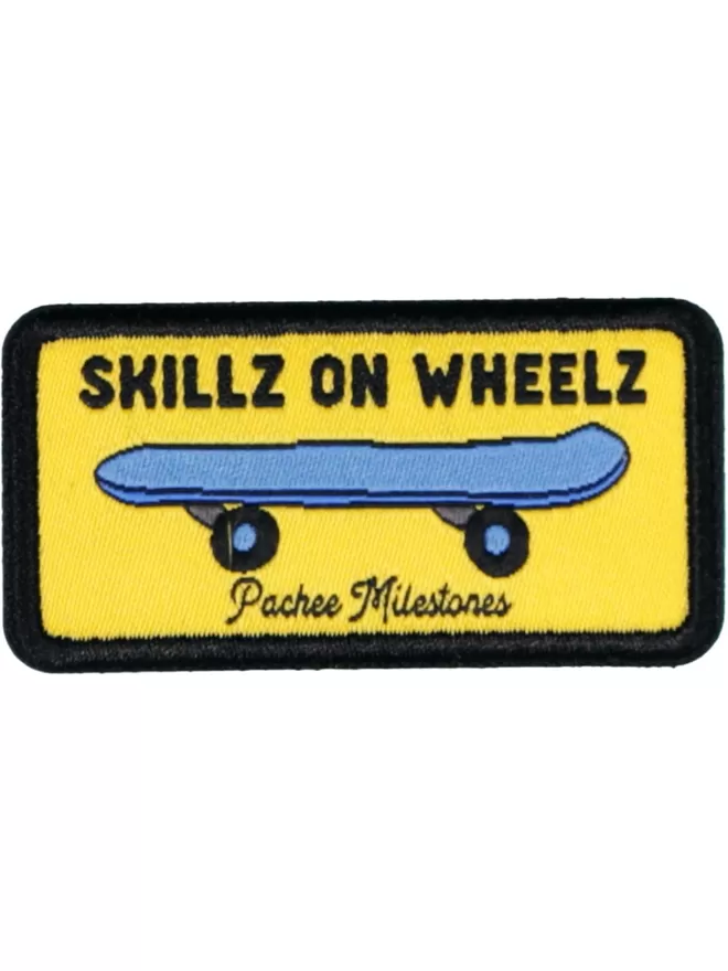 A rectangular, yellow patch with a blue skateboard in the centre. Above is written 'Skillz on Wheelz.'