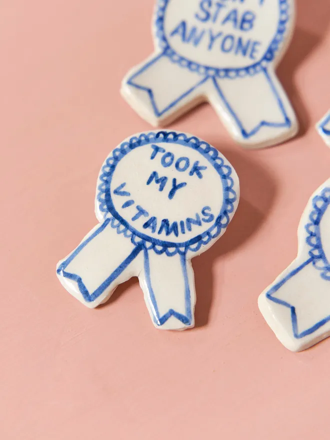  Blue Handmade Ceramic Award, a group of blue and white ceramic award badges sitting on a ink surface. 