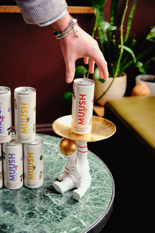 can of blood orange drink sitting on an astronaut-shaped tray