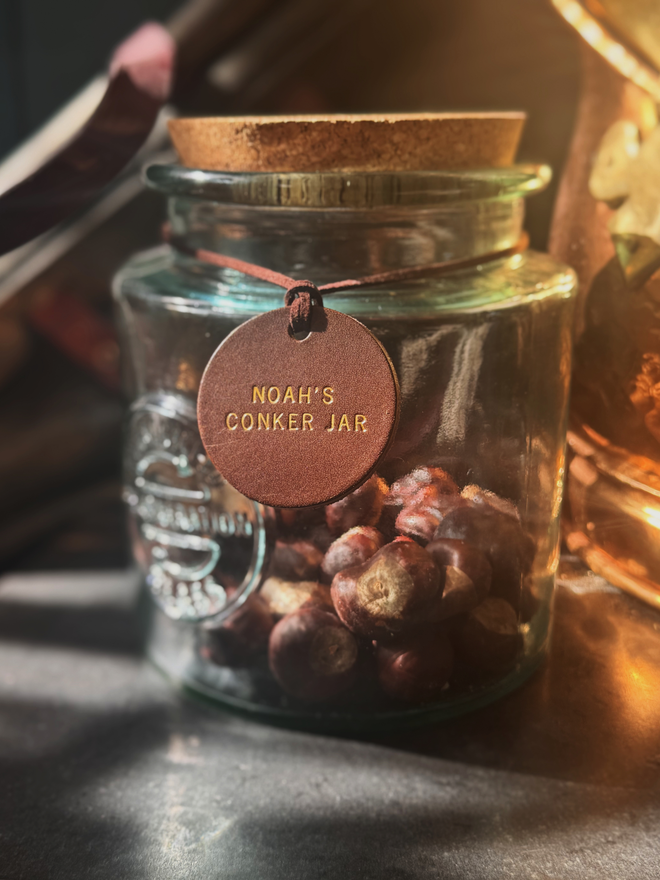 small brown leather conker label on glass jar.