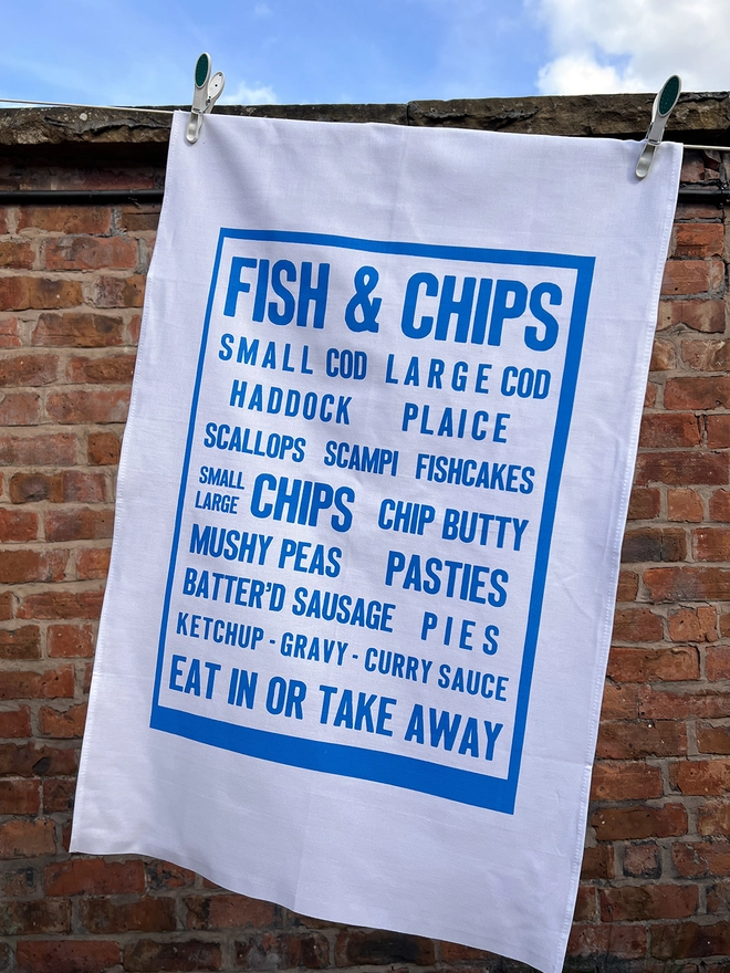 Mr.PS Fish & Chips tea towel hanging in the sunshine