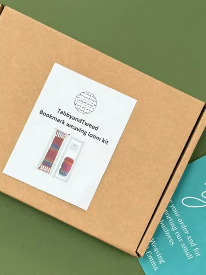 Cardboard box with a thank you sticker, on a green background. 