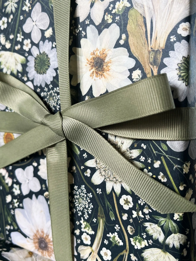 Luxury gift wrap paper sheets created from pressed white florals on a black background.