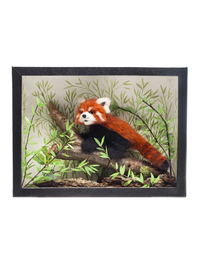 A miniature diorama featuring a red panda climbing a branch