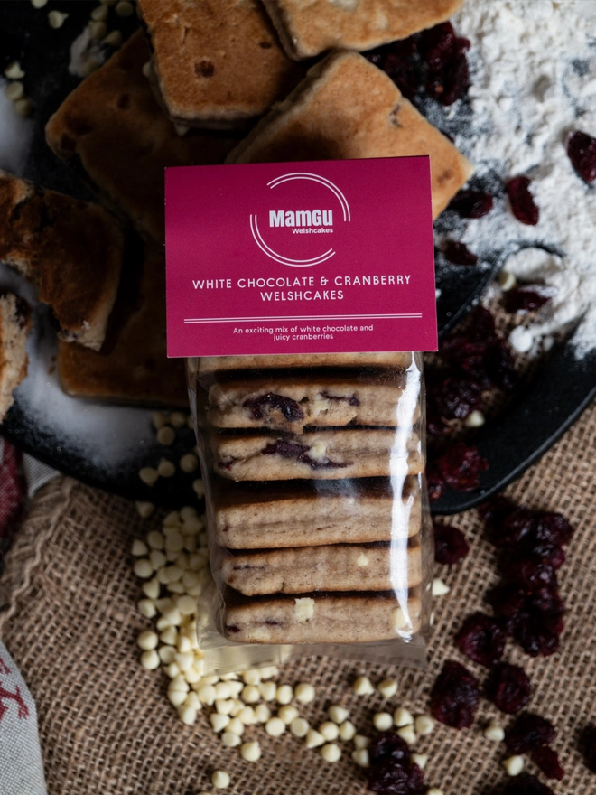 A 6 pack of White Chocolate and Cranberry Welsh Cakes pictured with raw ingredients  