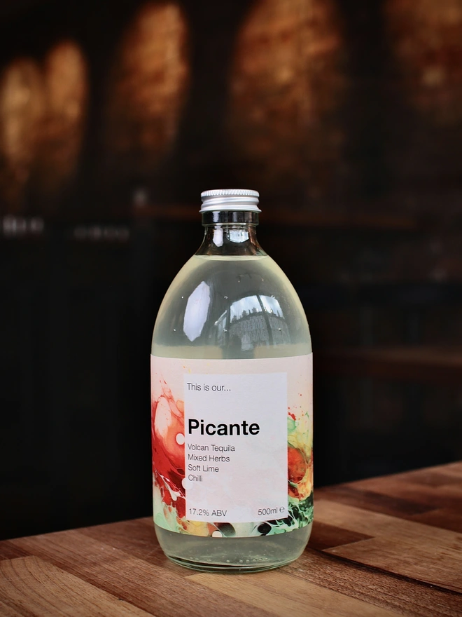 A bottle of Garden Picante shown against a moody interior background