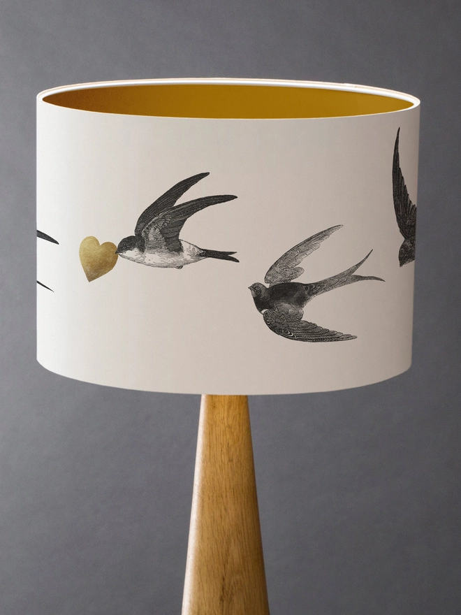 Handmade lampshade featuring graceful flying swallows swooping through a nature-inspired design, adding an elegant touch to any room.