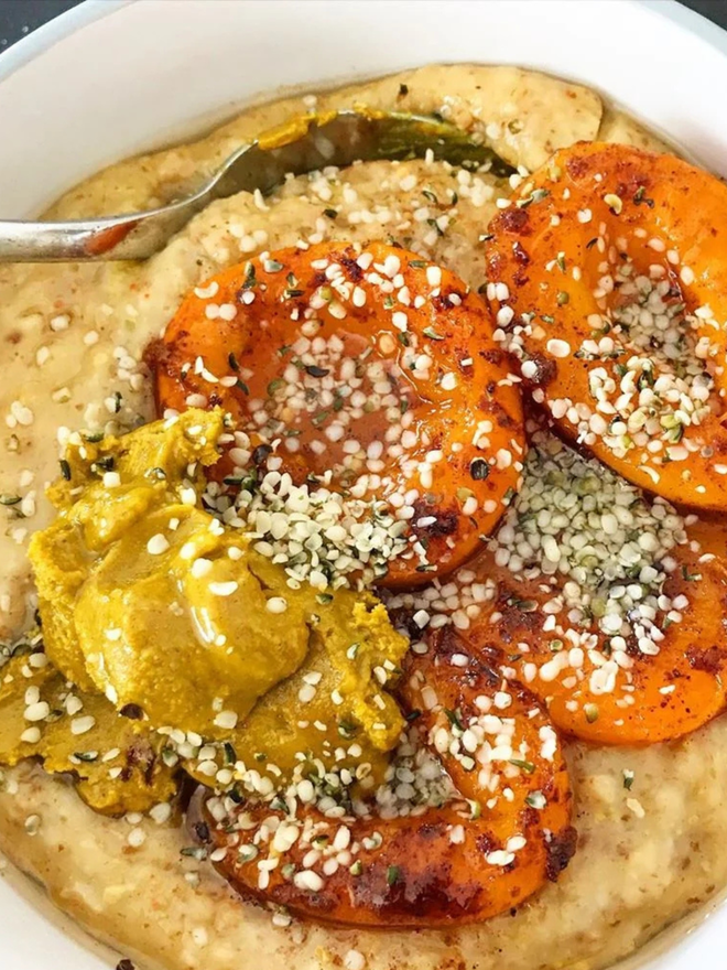 maple turmeric cashew butter. a bowl of porridge topped with sweet potato slices and maple turmeric cashew butter.