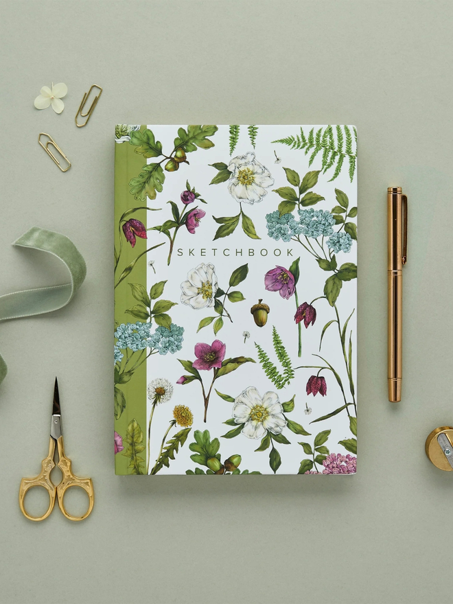 'Cottage Garden' A5 Hardback Sketchbook. a white floral sketchbook photographed on a plain grey background.