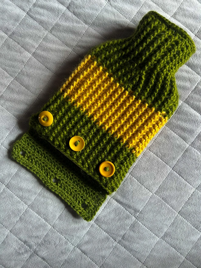 Green and yellow ribbed hot water bottle case showing buttons on back